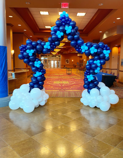 A balloon decorator designed a star-shaped balloon arch, featuring blue and white balloons, that stands as an elegant entrance in a hotel lobby in Omaha, Nebraska.