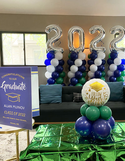 Graduation party setup in Nebraska featuring "2022" balloon decorations by a professional balloon decorator, and a 'follow your dreams' emblem.