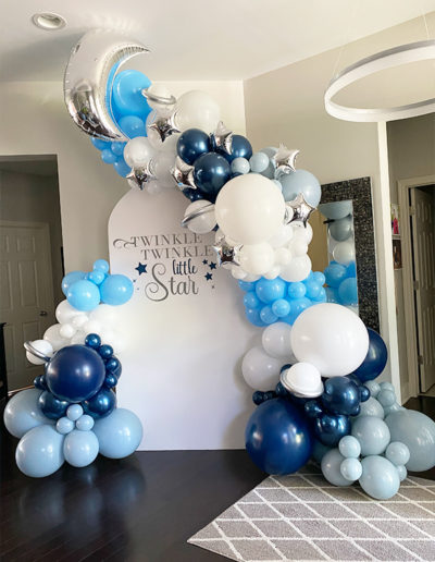 Decorative balloon arch made of blue, white, and silver balloons with a "twinkle twinkle little star" sign for a party in Omaha.